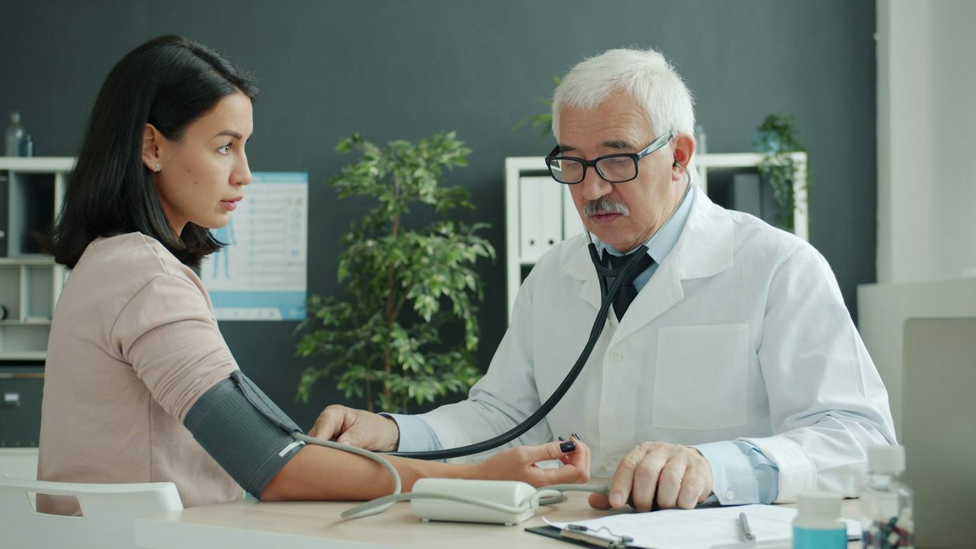A doctor taking a patient's blood pressure